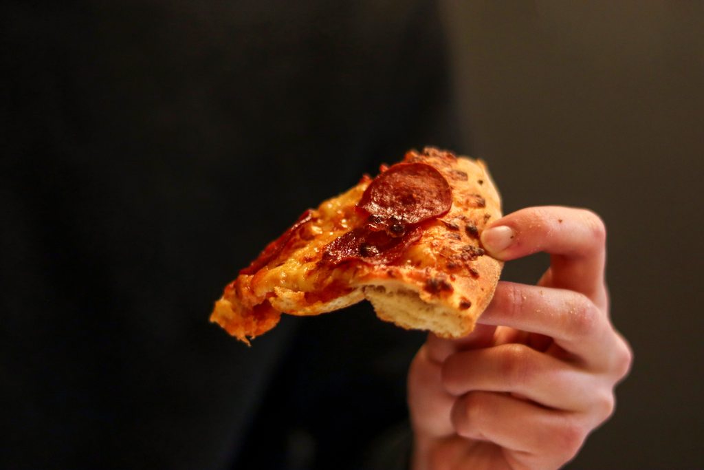 pizza slice held in a hand