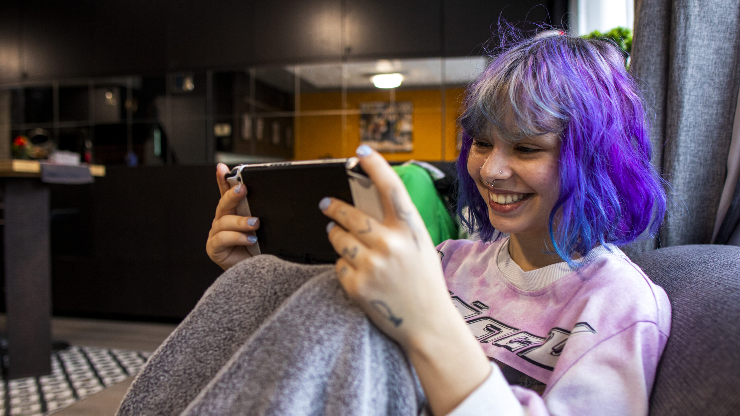 young girl with purple hair chilling indoors with ipad