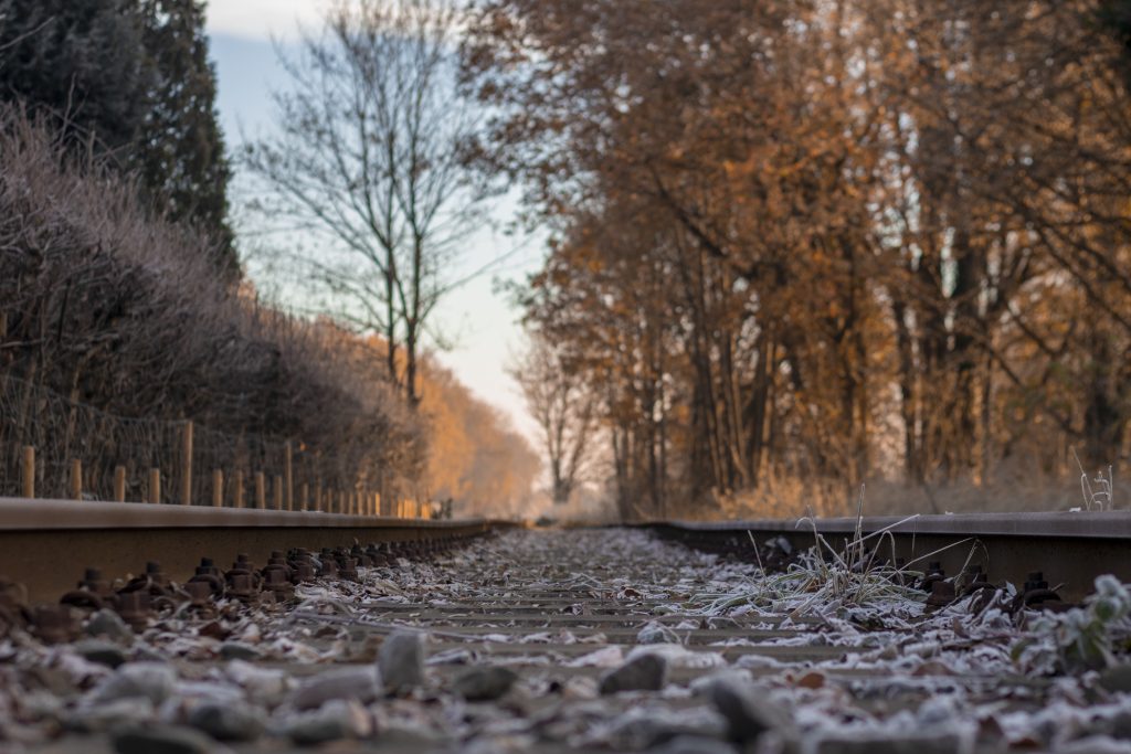 Frozen Dutch railroad with trees and blue sky