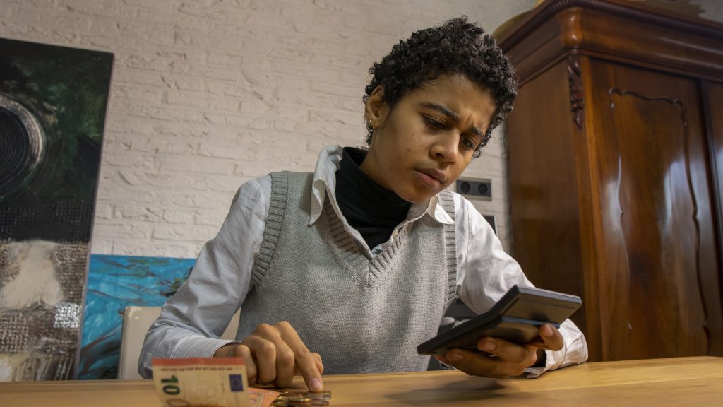 Girl counting her money with a calculator